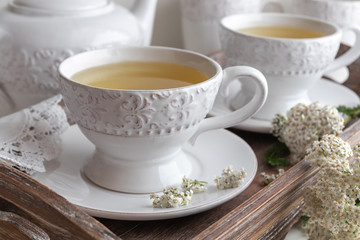 Obraz na płótnie Canvas Yarrow tea in white cups with fresh yarrow twigs