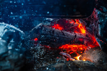 Smoldered logs burned in vivid fire. Atmospheric background with orange flame of campfire....