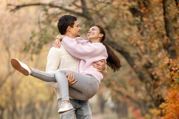 Couple in love in the autumn leaves