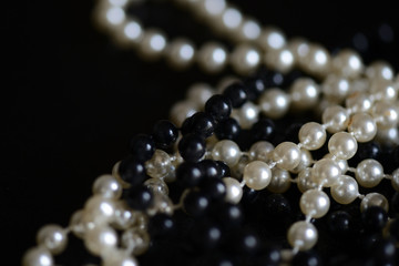 Black and white beads necklace on a dark background close up