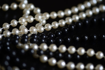 Black and white beads necklace on a dark background close up
