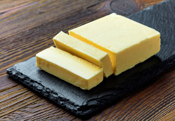 Sliced butter on wooden background