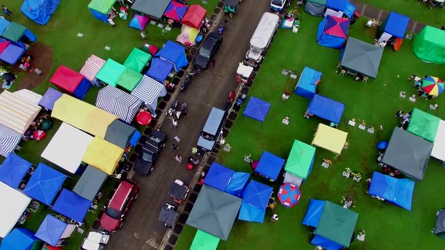All Saint's Day scene of Messy tented private cemetery where lie dead residents who can afford decent memorial lot and services. Descending Overhead Drone Aerial Shot