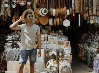 young stylish man pose in front of the souvenir shop