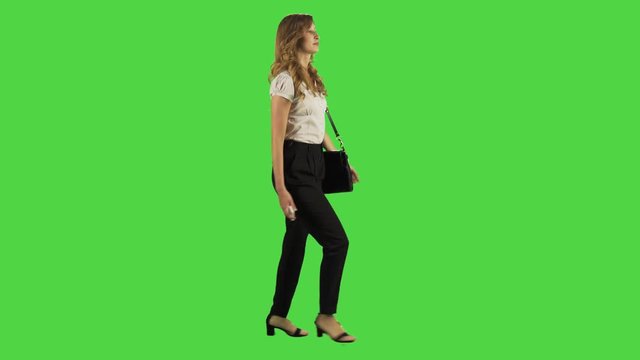 A young businesswoman walking and bumps into people, upset,  fast, full sideways shot, green screen.