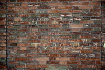 Brick wall with inscriptions of an ancient building.