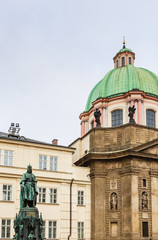 Fototapeta na wymiar Statue of Emperor Charles IV and Catholic church of St. Francis of Assisi. Prague, Czech Republic