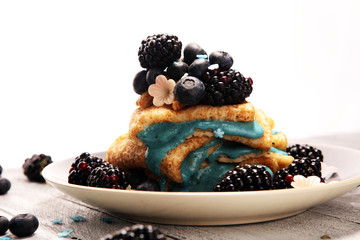 Delicious Tasty Homemade crepes or pancakes with blackberries,blueberries and blue spirulina nicecream.
