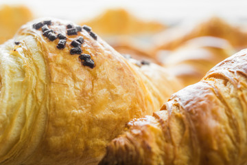 Croissant mit Schokoraspeln.  Frische Croissants. Food Hintergrund.