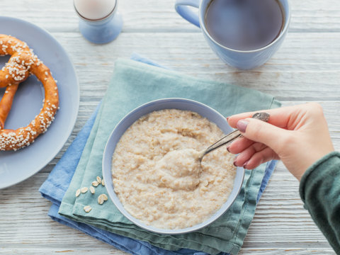 Oatmeal Porridge Bowl On The White Wooden Background.