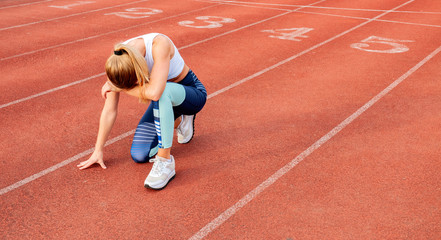 Tired woman runner taking a rest after run sitting on the running