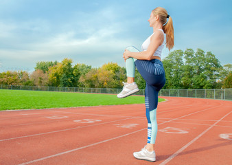 Fitness woman stretching legs before run on outdoors