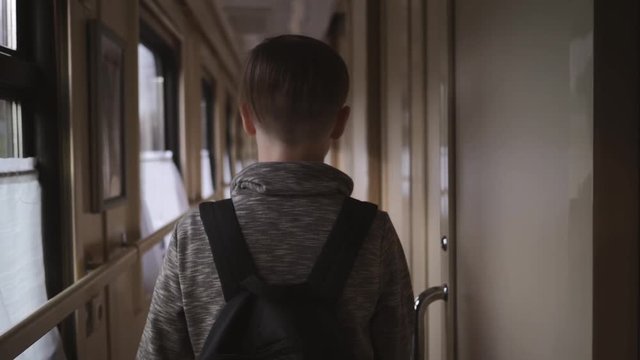 A boy with a backpack is on the train car. The concept of travel and tourism. Holidays on vacation. World travel