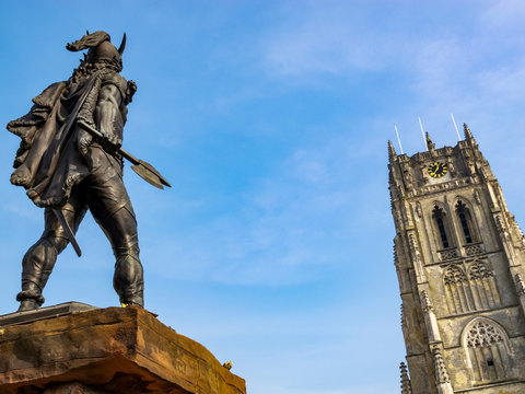 Rear view of the statue of Ambiorix in Tongeren, the oldest town in Belgium, the tower of Tongeren Basilica of Our Lady in the background