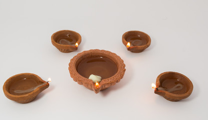 Closeup of Diwali terracotta diyas on Isolated white background.