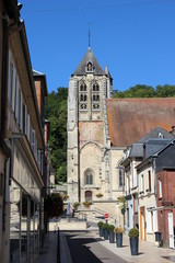 Fototapeta na wymiar Clocher de l'église Saint-Nicolas depuis une rue de Beaumont-le-Roger