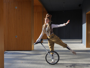 Young lady in a fantasy clothes with unicycle © Alexey Kuznetsov