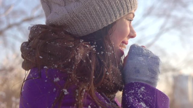 Winter holidays. Beauty joyful model girl having fun in winter park. Slow motion 4K UHD video footage. 3840X2160