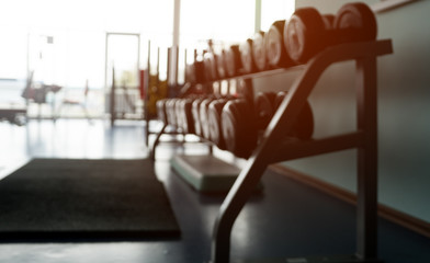 High rack with many dumbbell in a gym club. Rows of sport dumbbells in modern new sports club....