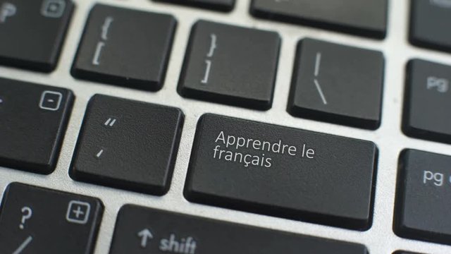 Learn French button on computer keyboard, female hand fingers press key