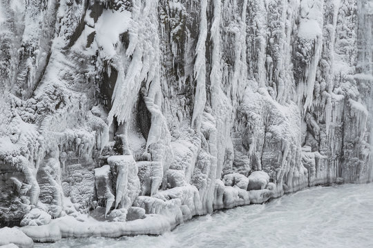 Rocks covered with spray from a waterfall that is frozen in winter