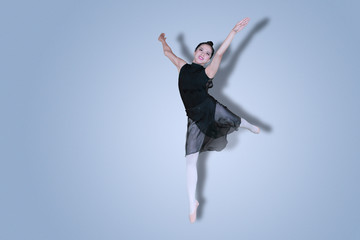 Fototapeta na wymiar Pretty ballerina performing dances on studio