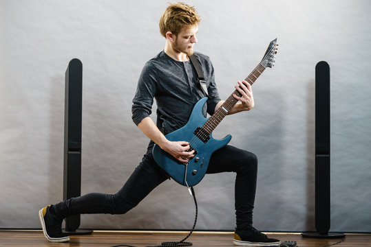 Young man playing electric guitar