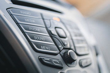 Display of audio system panel with media, phone, sound, radio and menu buttons. Modern car control...
