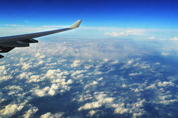 Obraz premium the wing of the plane in the clouds