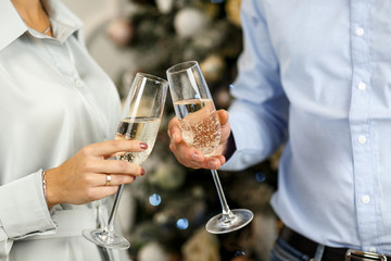 couple makes a wish under the clink of glasses in the New Year holidays