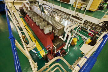 Fototapeta na wymiar Panoramic view of main engine on a merchant ship in the engine room