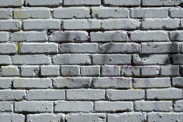 Grey painted brick wall with graffiti stains