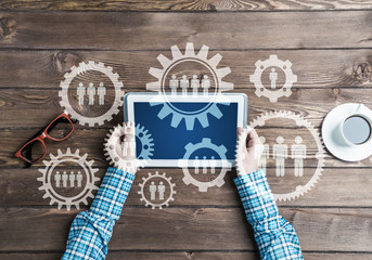 Concept of teamworking and connection with gears mechanism and tablet pc