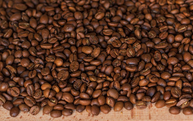 Closeup of fragrant roasted coffee beans on a wooden board. Selective focus. place for text.