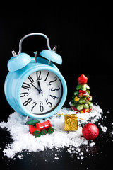 Alarm clock and new year decorations on black background