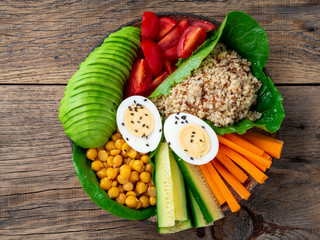 Vegetarian Buddha's bowl, a mix of vegetables. Avocado, quinoa, chickpeas, vegetables, eggs, top view, copy space