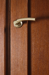 Obraz premium Closeup photo of brown wooden door with metal handle