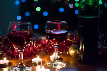 Glasses with red wine. Garlands in the background.