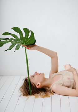 Dreaming model posing with huge leaf