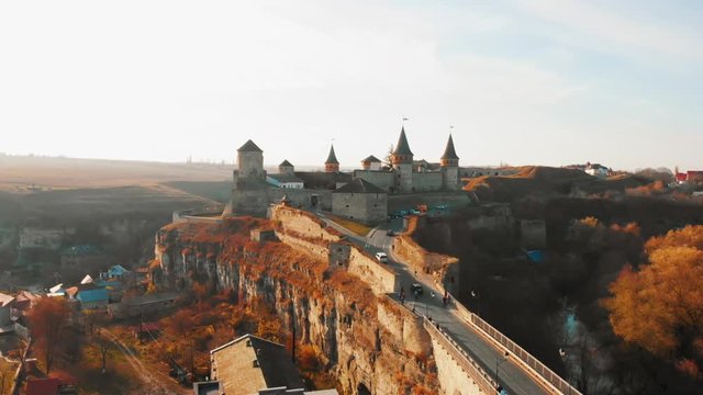 Aerial view of Kamianets-Podilskyi fortress in Ukraine. Castle built in 14th century on Smotrych river. Architecture of Middle Ages in our time. Travel concept. Autumn sunflares light