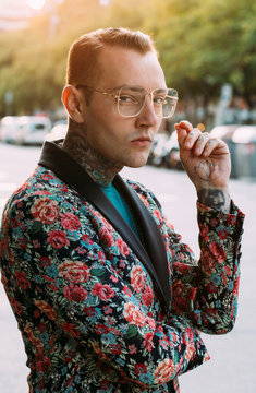 Tattooed handsome man with colourful flower jacket around the city.