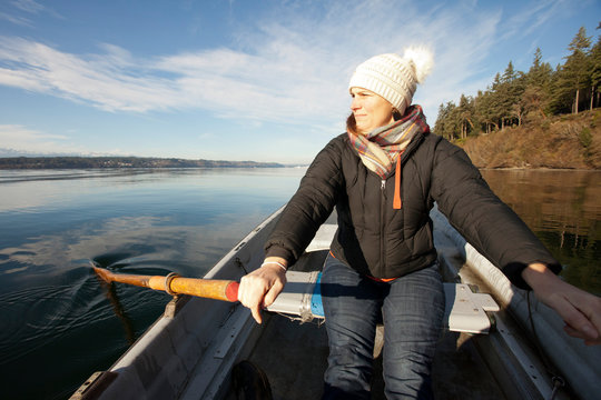 Woman rows a rowboat, enjoying a quiet day on Pugeot Sound