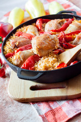 Chicken thighs and legs baked over a bed of rice and red bell pepper