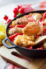 Chicken thighs and legs baked over a bed of rice and red bell pepper