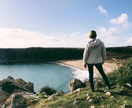 Woman standing overlooking Barafundle Bay in Wales, UK.
