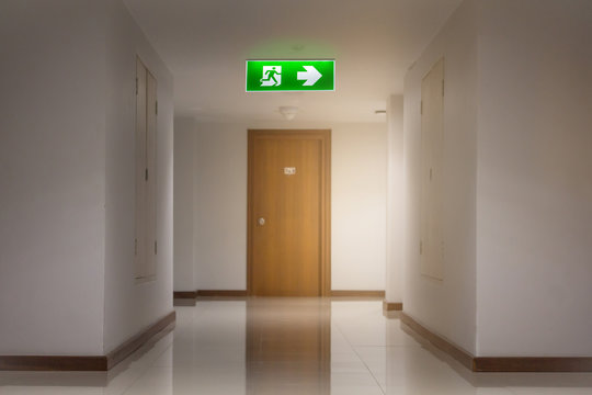 green emergency exit sign in hotel showing the way to escape