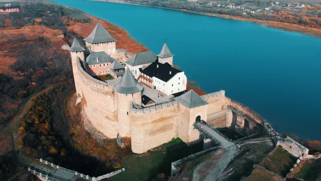Panorama aerial view of old castle Hotin near river. Khotyn Fortress - medieval castle on yellow autumn hills. Ukraine, Eastern Europe. Architecture of Middle Ages in our time.