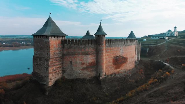 Panorama aerial view of old castle Hotin near river. Khotyn Fortress - medieval castle on yellow autumn hills. Ukraine, Eastern Europe. Architecture of Middle Ages in our time.