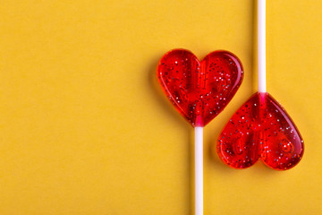 Two red sweet tasty lollipops in shape of heart