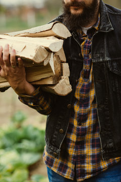 man carries wood pieces